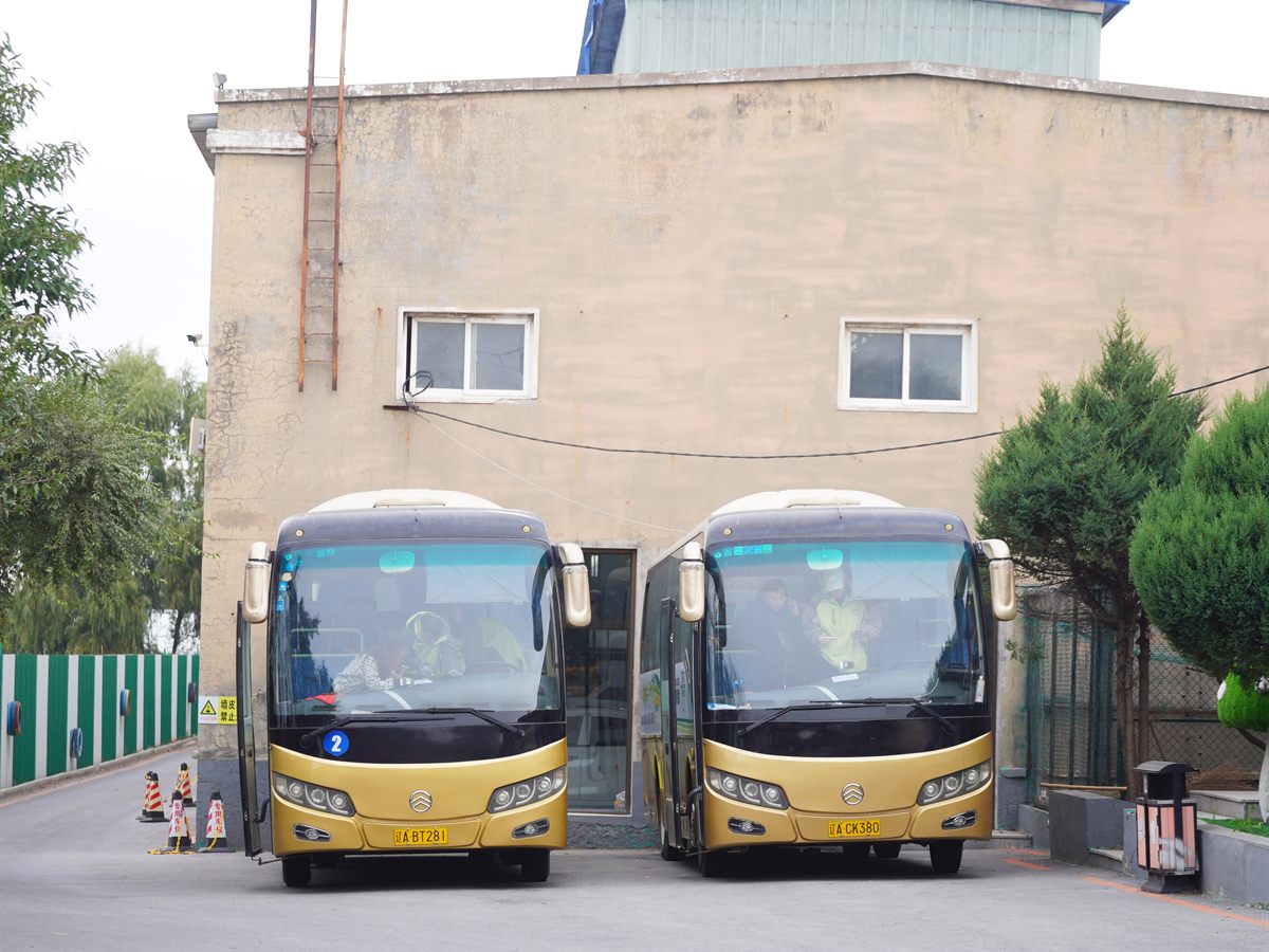 两辆八棵树驾校班车停在院内